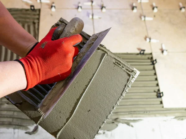 Applying thinset mortar on a tile. Apply the adhesive, closeup. — Stock Photo, Image