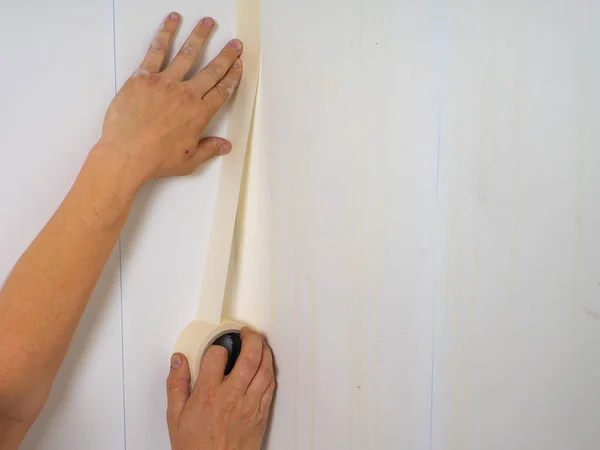 Human hands holding adhesive tape and preparing for painting. Close Up. — Stock Photo, Image