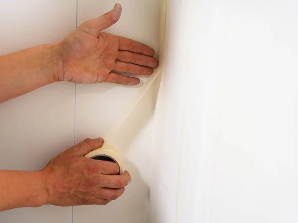Human hands holding adhesive tape and preparing for painting. Close Up. — Stock Photo, Image