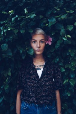 Yeşil yapraklı arka planda güzel bir genç kadının portresi.