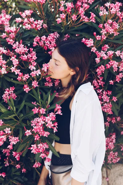 Hermosa Joven Posando Cerca Arbusto Con Flores Color Rosa — Foto de Stock
