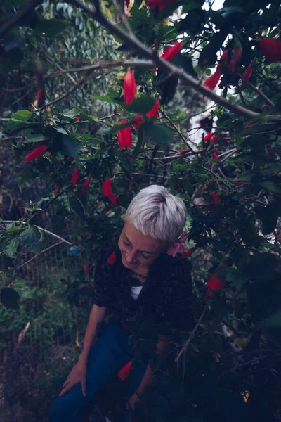 Giovane Donna Bionda Giardino Vicino All Albero Con Fiori Rossi — Foto Stock