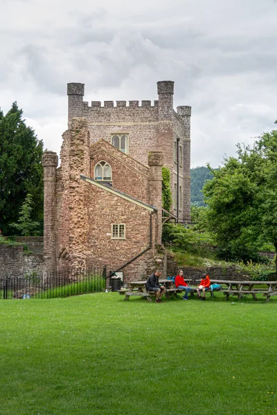 英国威尔士阿伯加文尼城堡的米尔街塔楼 人们坐在花园的野餐长椅上 — 图库照片