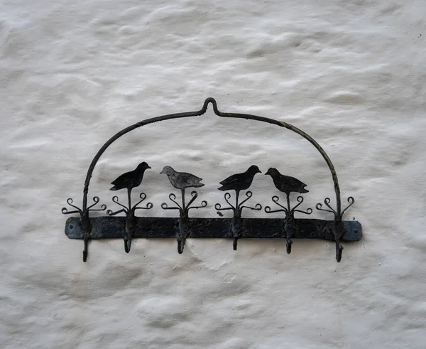 Black Metal Bird Hooks White Stone Wall — Stock fotografie