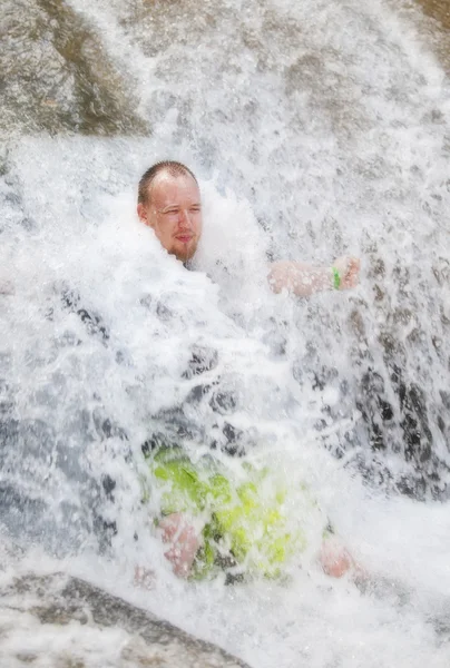 Mann im Wasserfall Stockbild