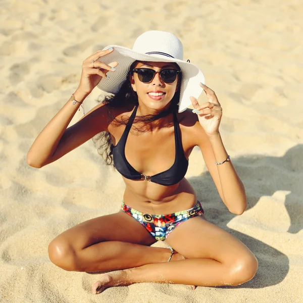 Жінка в капелюсі і сонцезахисних окулярах на пляжі — стокове фото