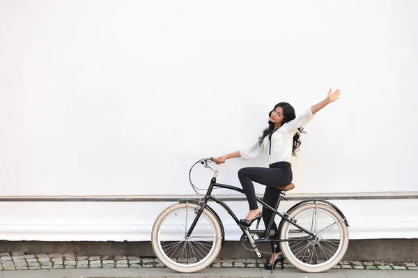 Vacker glad kvinna sitter på cykel och ge salut gestu — Stockfoto