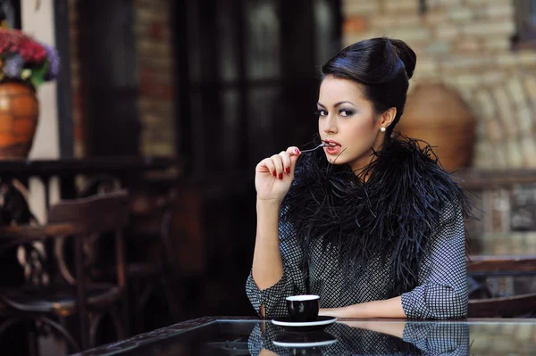 Kafede bir fincan kahveyle oturan genç ve güzel bir kadın. — Stok fotoğraf