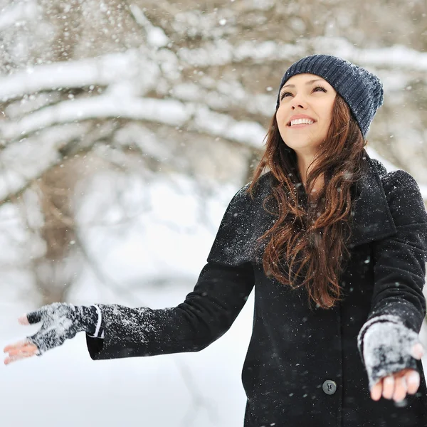 Жінка грає зі снігом в зимовому парку — стокове фото