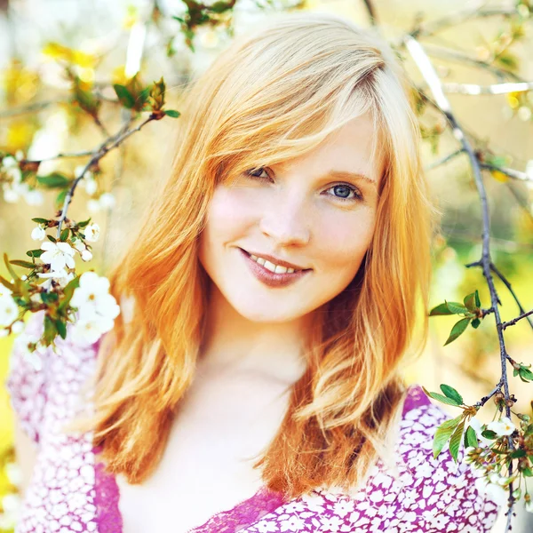 Krásná mladá dívka v kvetoucí strom — Stock fotografie
