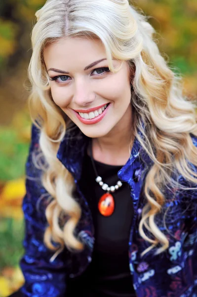 Hermosa mujer sonriente elegante de pie en un parque en otoño — Foto de Stock