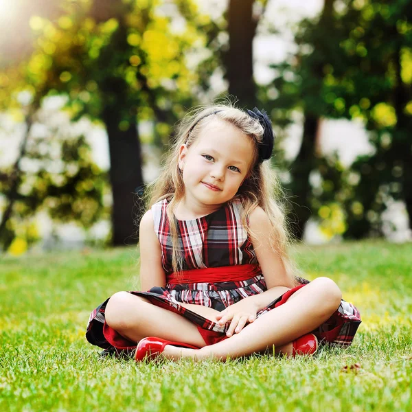 Söt liten flicka stående i en sommar grön park — Stockfoto