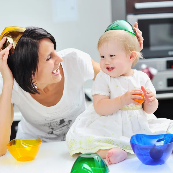 Sweet little girl and mother having fun in a kitchen — Stock Photo, Image