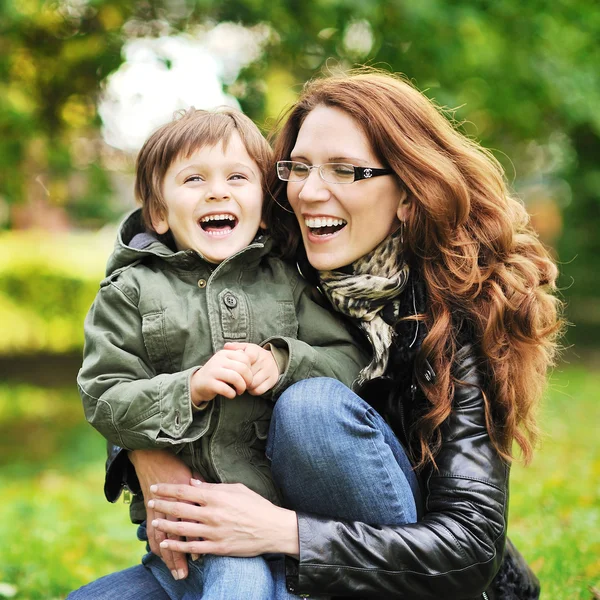 Mamma och hennes lilla son ha roligt i en park — Stockfoto