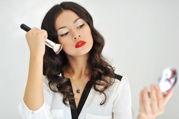 Retrato de mujer joven atractiva con cepillo de maquillaje sobre blanco —  Fotos de Stock