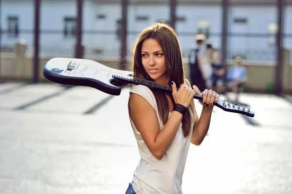 Jolie jeune femme avec guitare portrait de mode en plein air — Photo