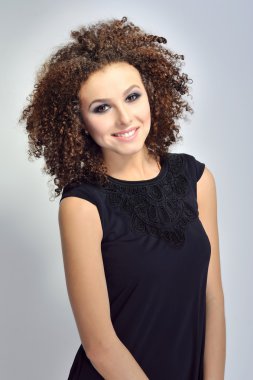 Gülümseyen bir kıvırcık saçlı Avrupa kadın portresi
