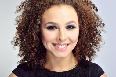 Kıvırcık saçlı kadın gülümseyerek yakın çekim 