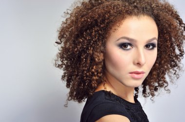 Muhteşem kıvırcık saçlı güzel bir esmer.