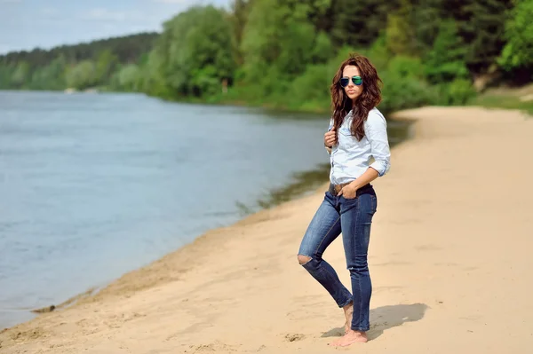 Ung kvinna walkin på en strand — Stockfoto