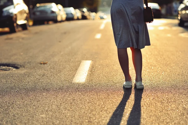 Close-up van jonge vrouw benen op de weg — Stockfoto