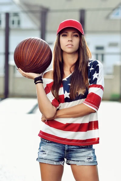 Sexy bruneta žena v ruce drží basketbal — Stock fotografie