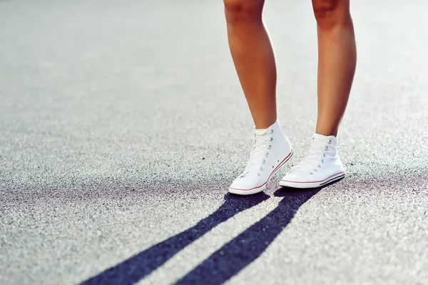 Sneakers på flicka. Ung kvinna ben. Utomhus — Stockfoto