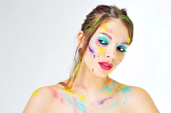 Bella ragazza con spruzzi di vernice colorata sul viso — Foto Stock
