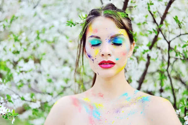 Beautiful woman with colored paint on face outdoor — Stock Photo, Image