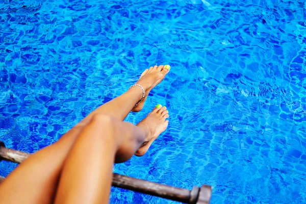 Gambe donna in acqua blu — Foto Stock