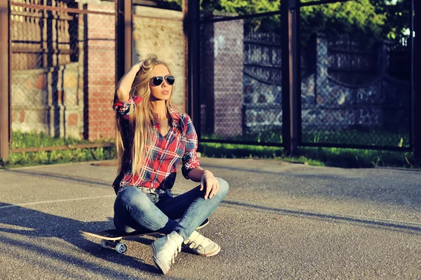 Красивая молодая женщина позирует со скейтбордом, стиль жизни моды — стоковое фото
