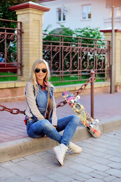 Stijlvolle jonge vrouw met skateboard — Stockfoto