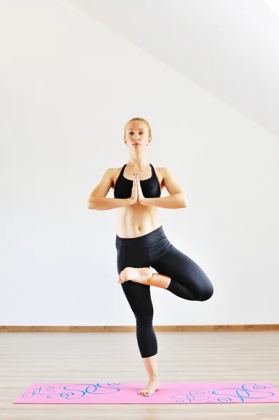 Young slim sports woman standing in yoga pose — Stock Photo, Image
