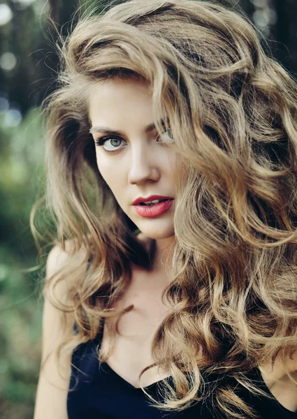 Красивая молодая женщина лицо крупным планом с макияжем и коричневый кудрявый h — стоковое фото