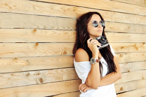 Modern snygg tjej med gamla kameran bär solglasögon och — Stockfoto