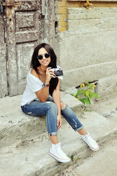 Hermosa joven posando con la vieja cámara de moda — Foto de Stock