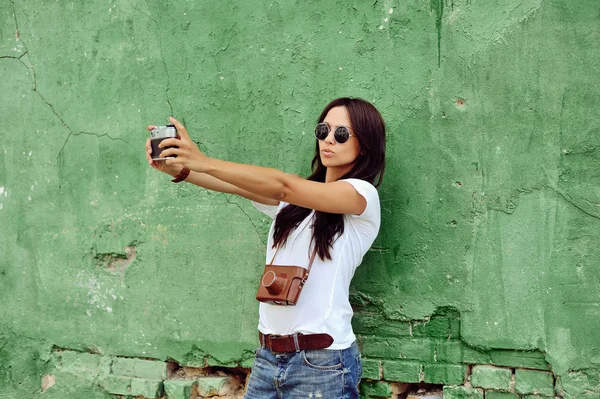 Hermosa chica tomada fotos de su auto en la cámara vintage — Foto de Stock