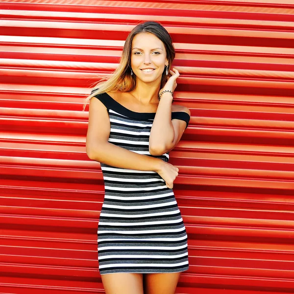 Pretty young woman posing near red wall — Stock Photo, Image
