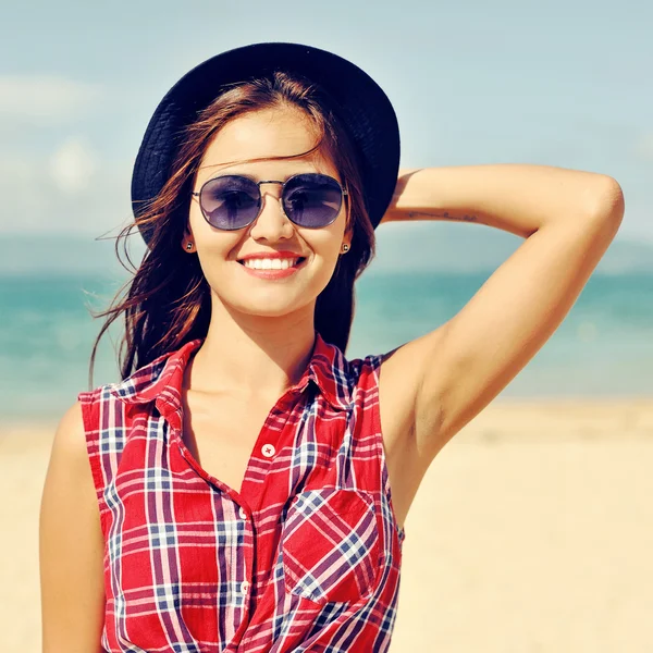 Jeune femme séduisante en chapeau et lunettes de soleil — Photo