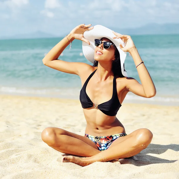 Mujer en sombrero tomando el sol en la playa —  Fotos de Stock