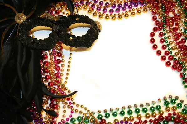 Mardi Gras kralen en masker stationaire / achtergrond Stockfoto