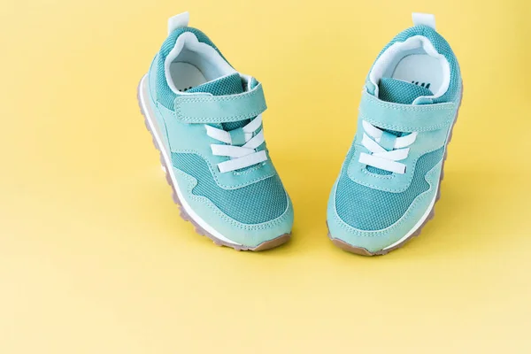 Groene sneakers op gele pastelachtergrond. Minimaal concept voor sport en activiteit. — Stockfoto