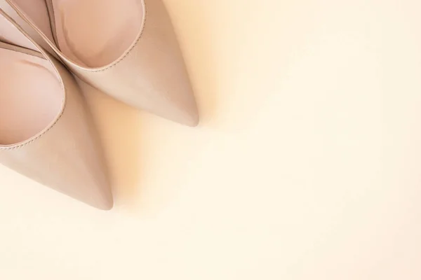 Klassieke beige vrouwen hoge hak schoenen op pastel achtergrond. Minimale vrouwelijke achtergrond. Mode blog en verkoop concept. — Stockfoto