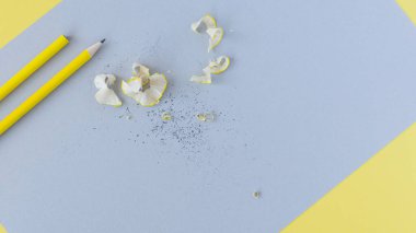 Sarı kalemler ve gri kağıt arkaplanındaki talaşlar