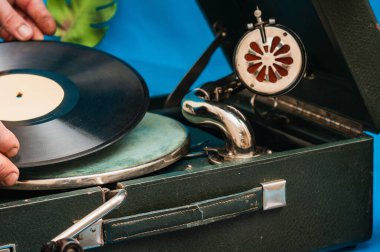 Yetişkin adam vinil plak koyuyor. Vinil çalar, retro