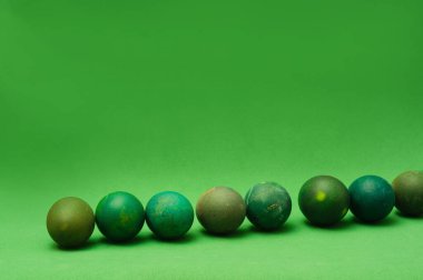 Yeşil arka planda bir sürü yeşil Paskalya yumurtası. Monochro