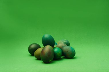 Yeşil arka planda bir sürü yeşil Paskalya yumurtası. Monochro
