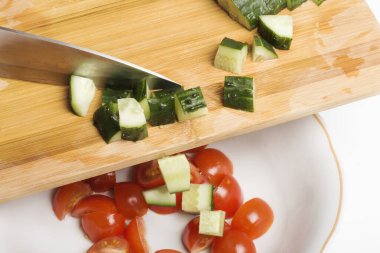 Dilimlenmiş taze salatalıklar salata kasesine aktarılır..