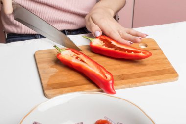 Kırmızı biberleri doğrama tahtasında dilimliyorum..