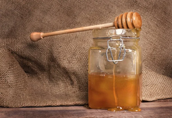 Ένα Βάζο Μέλι Ένα Κουτάλι Στο Φόντο Της Vintage Λινάτσα — Φωτογραφία Αρχείου
